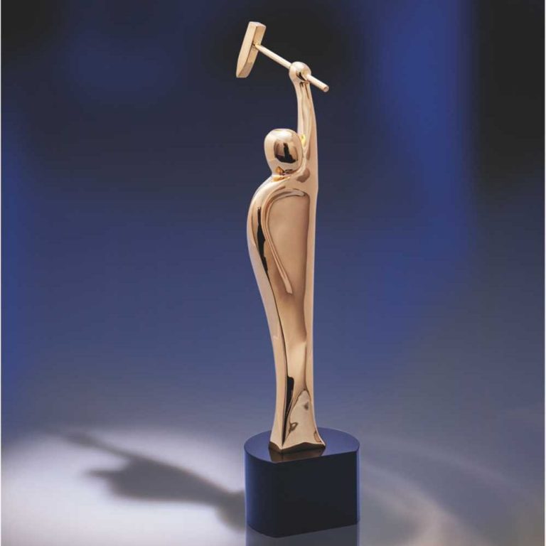 Eine goldene Auszeichnung in Form einer stilisierten Figur mit einem Hammer.